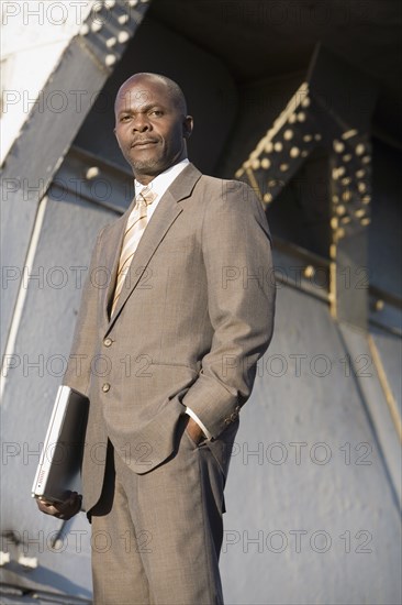 African American businessman holding laptop