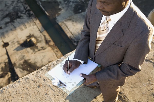 African American businessman writing on clipboard