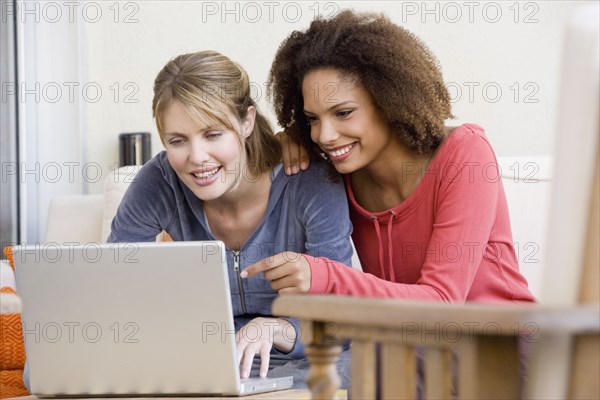 Multi-ethnic women looking at laptop