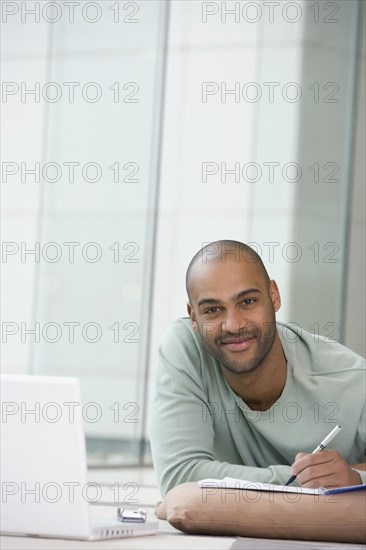 African man writing on notepad