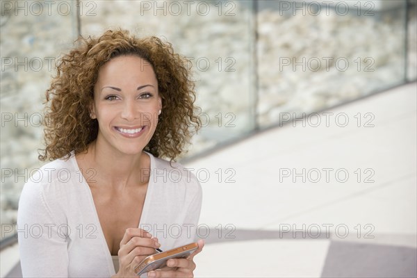 African businesswoman holding electronic organizer