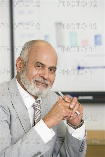 Senior African businessman holding pen
