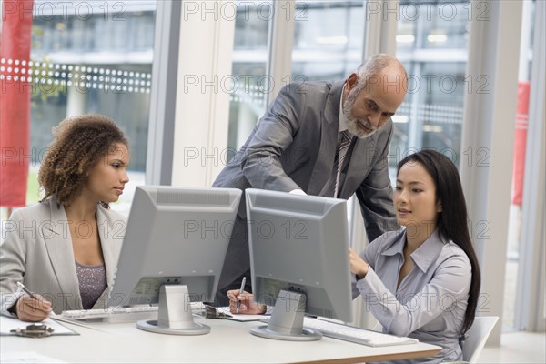Multi-ethnic businesspeople looking at computer