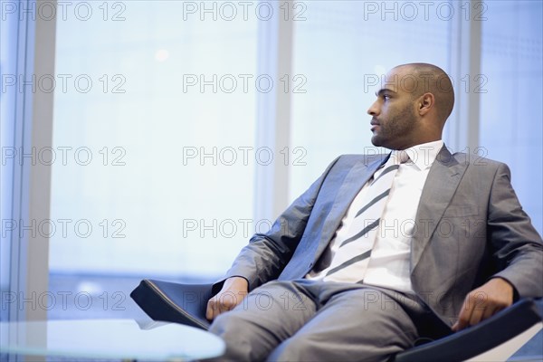 African businessman looking out window