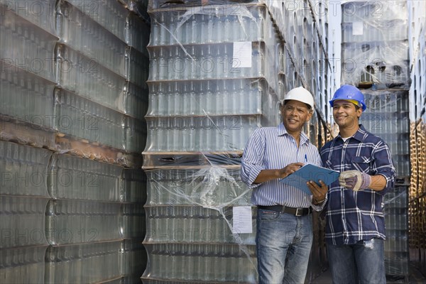 Manager talking with worker at processing plant