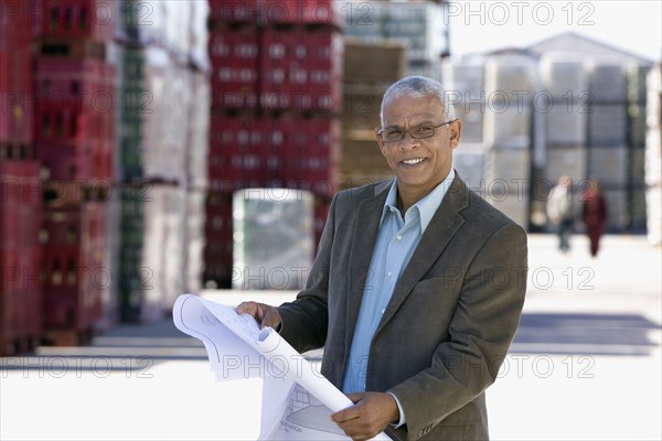 African architect reviewing blueprints at factory
