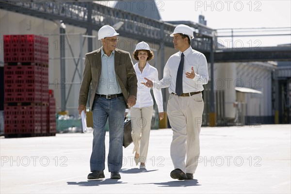 Business people walking outside factory