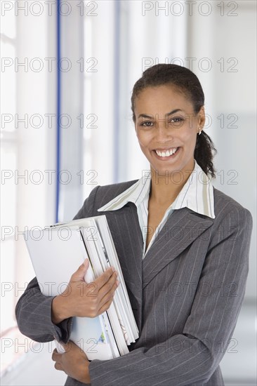 Confident African businesswoman holding paperwork