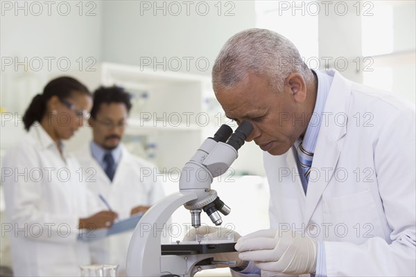 African scientist performing analysis in laboratory with microscope