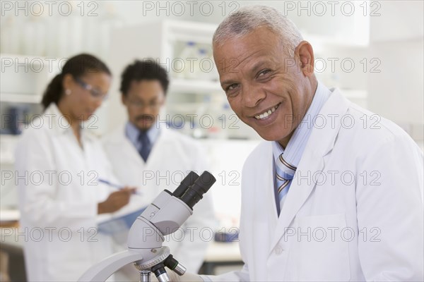 African scientist performing analysis in laboratory with microscope