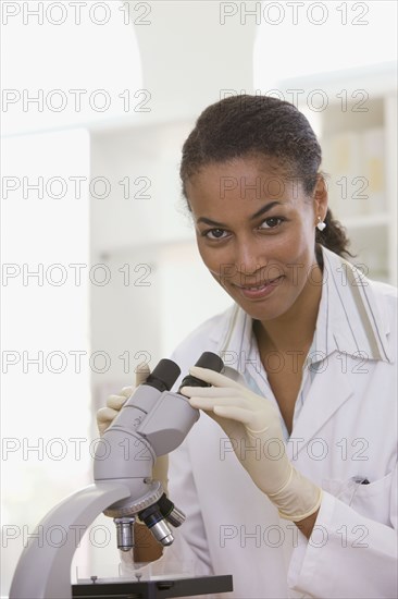 African scientist performing analysis in laboratory with microscope