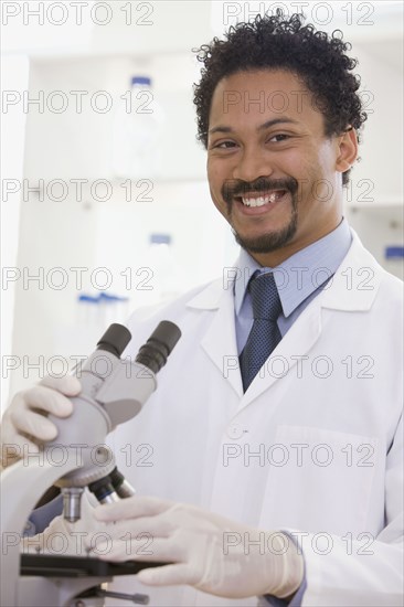 African scientist performing analysis in laboratory with microscope