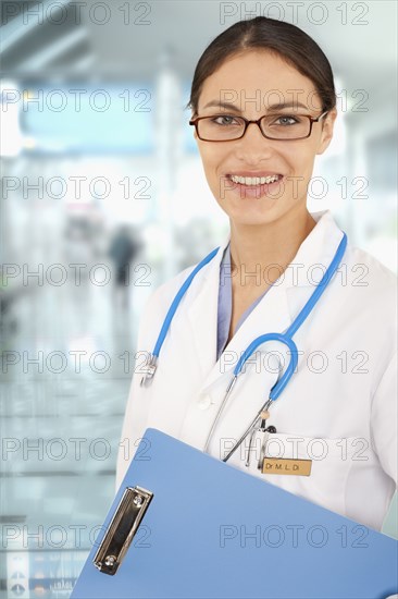 Mixed race doctor holding medical chart in hospital