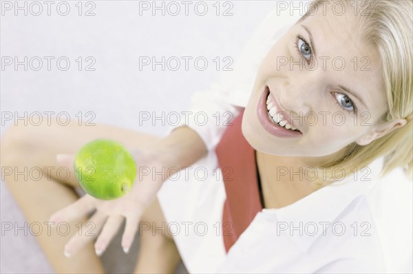 Smiling woman playing with apple