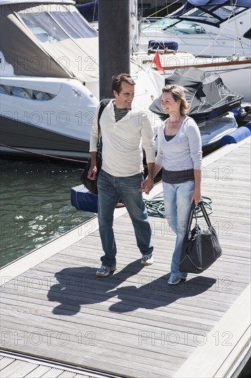 Caucasian couple walking on dock