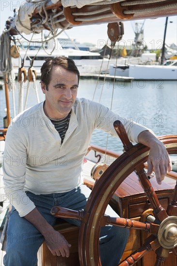 Caucasian man steering sailboat