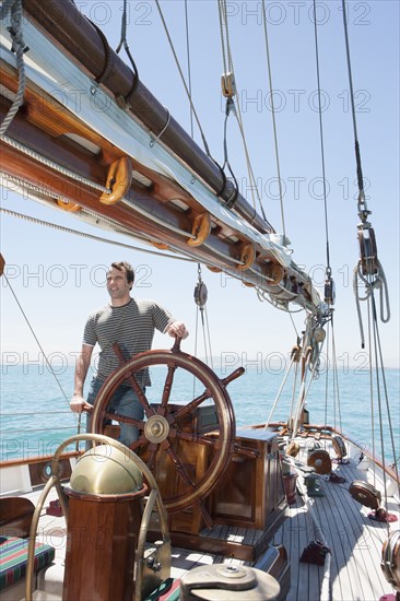 Caucasian man steering sailboat