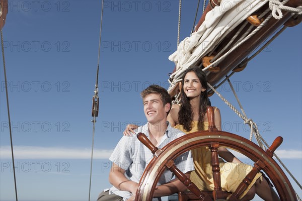 Caucasian couple at helm sailboat