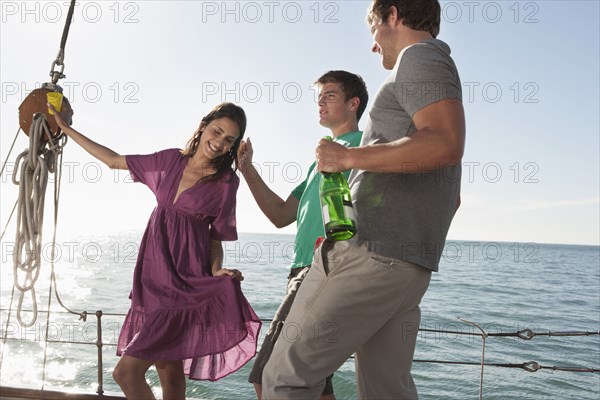 Caucasian friends celebrating on sailboat