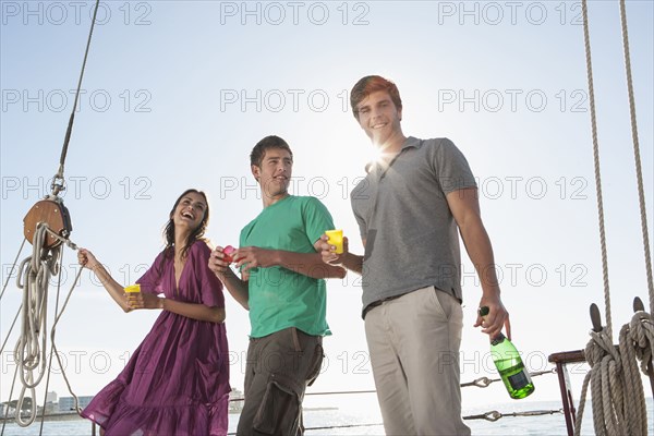 Caucasian friends laughing on sailboat