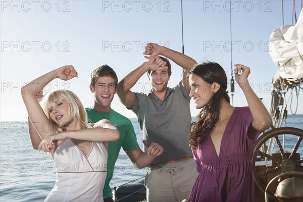 Caucasian friends dancing on sailboat