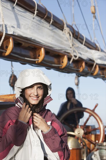 Caucasian woman wearing jacket on sailboat