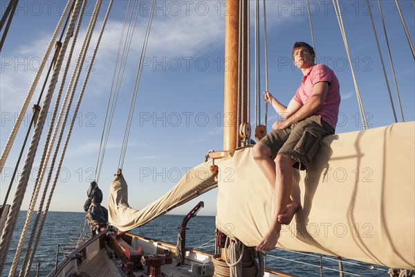 Caucasian man relaxing on sailboat