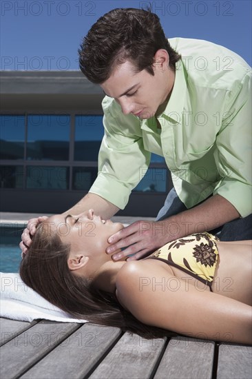 Caucasian man giving woman CPR