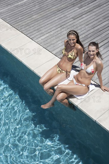 Caucasian women relaxing by swimming pool