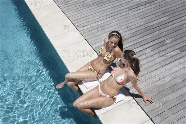 Caucasian women relaxing by swimming pool