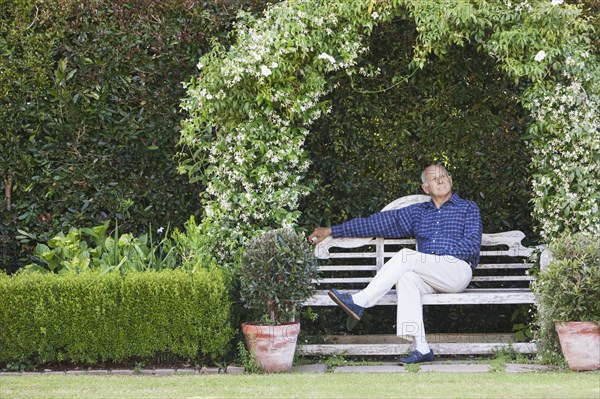 Senior Caucasian man sitting on garden bench