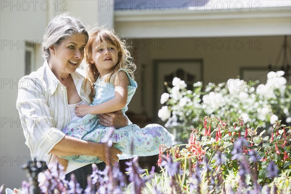 Grandmother and granddaughter admiring flowers