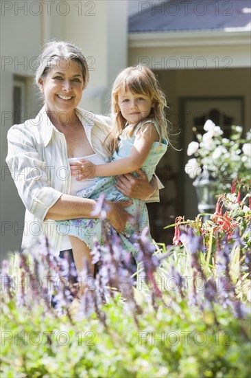 Grandmother and granddaughter admiring flowers