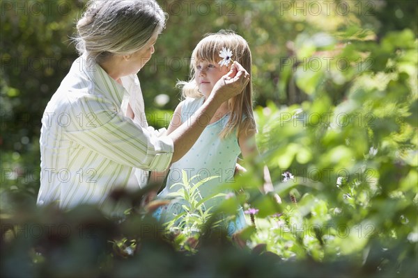 Grandmother and granddaughter picking flowers