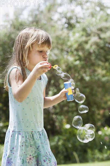 Caucasian girl blowing bubbles outdoors