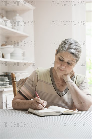 Caucasian woman writing in journal