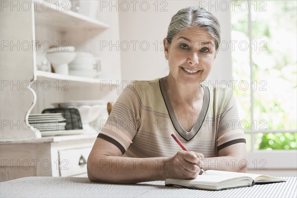 Caucasian woman writing in journal