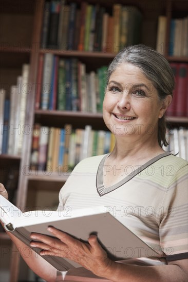 Caucasian woman reading book in library