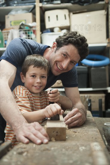 Caucasian father and son working in woodshop