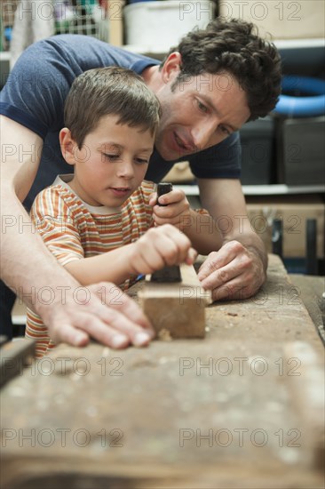 Caucasian father and son working in woodshop