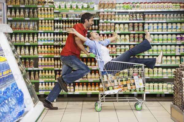 Caucasian couple playing in grocery store