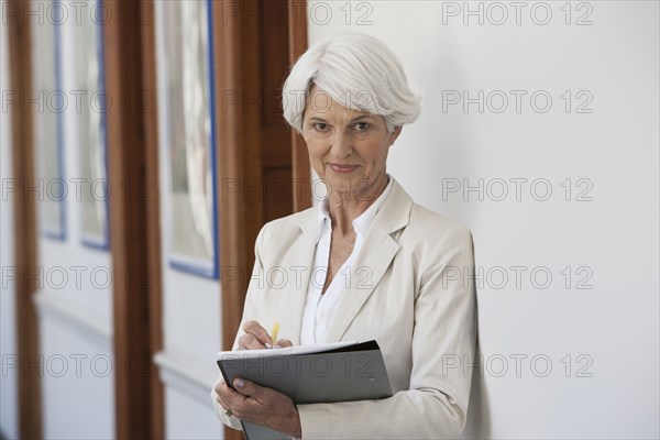 Senior Caucasian businesswoman making notes in office
