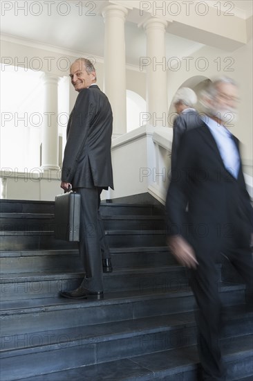 Senior Caucasian businessmen climbing office steps