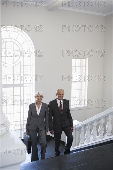 Senior Caucasian business people climbing office steps