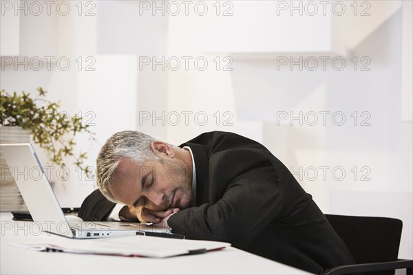 Businessman sleeping at desk in office