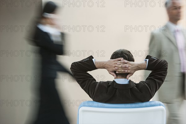 Businessman relaxing in busy lobby