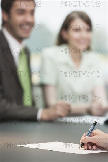 Close up of businesswoman making notes in meeting