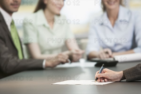 Close up of businesswoman making notes in meeting