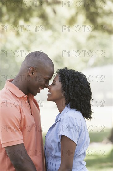 Couple rubbing noses in park