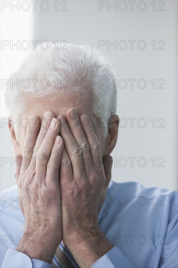 Caucasian businessman covering his face